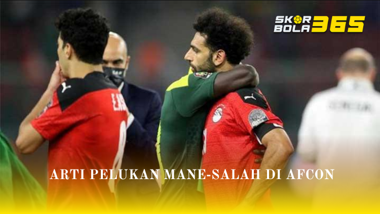 Sadio Mane yang mengenakan jersey hijau Senegal memeluk Mohamed Salah yang mengenakan jersey merah Mesir dari belakang sebagai bentuk rasa hormat, terdapat teks Arti Pelukan Mane-Salah di AFCON dan logo SKORBOLA365.