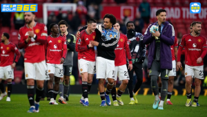 Para pemain Manchester United berdiri berjajar sebelum pertandingan Liga Champions UEFA dengan mengenakan jersey kandang berwarna merah di stadion yang dipenuhi suporter.