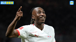Pemain RB Leipzig mengenakan jersey putih merayakan gol dengan mengangkat tangan